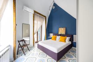 ein Schlafzimmer mit einem Bett und einer blauen Wand in der Unterkunft Leticia's Apartment by Wonderful Italy in Neapel