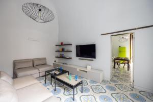 ein Wohnzimmer mit einem Sofa und einem TV in der Unterkunft Leticia's Apartment by Wonderful Italy in Neapel