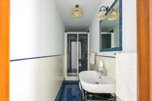 ein Bad mit einem Waschbecken und einem Spiegel in der Unterkunft Leticia's Apartment by Wonderful Italy in Neapel