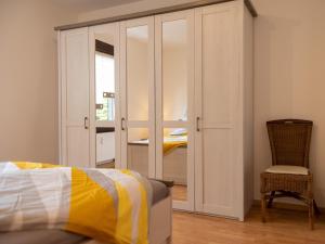 a bedroom with a closet and a bed and a chair at Ferienwohnung Severin in Bottrop