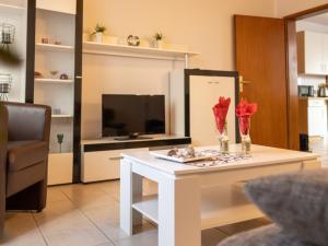 ein Wohnzimmer mit einem weißen Tisch und einem TV in der Unterkunft Ferienwohnung Severin in Bottrop