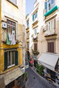 eine Gasse zwischen zwei Gebäuden mit Kleidung, die von einem Fenster hängt in der Unterkunft Leticia's Apartment by Wonderful Italy in Neapel