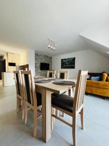 Apartament Primula 1 في غاوركي: طاولة وكراسي خشبية في غرفة المعيشة