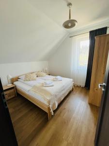 a bedroom with a bed and a window at Apartament Primula 1 in Jaworki