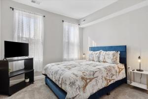 巴尔的摩Charm City Homestay in Washington Village的一间卧室配有蓝色的床和一台平面电视