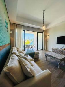 a living room with a couch and a television at Summer beachfront apartment in Belle Mare