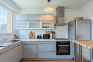 a kitchen with white cabinets and a stove top oven at One bedroom apartment with balcony, city center in Tourcoing