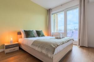 a bedroom with a bed and a large window at One bedroom apartment with balcony, city center in Tourcoing