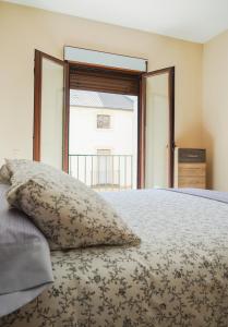 Schlafzimmer mit einem Bett mit einem Kissen und einem Fenster in der Unterkunft Casa de los Abuelos in Úbeda