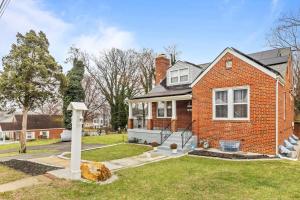 a red brick house with a yard at Short Drive to Capitol Hill-Convenient MD Homestay in Capitol Heights