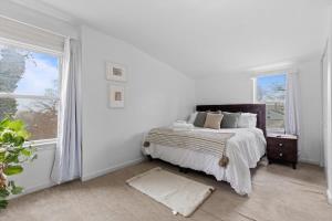 a white bedroom with a bed and a window at Short Drive to Capitol Hill-Convenient MD Homestay in Capitol Heights