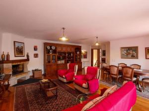 een woonkamer met rode meubels en een open haard bij Varanda do Outeiro in Melgaço