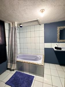 La salle de bains bleue et blanche est pourvue d'une baignoire et d'un lavabo. dans l'établissement Alta Terra Hospedajes, à Quetzaltenango