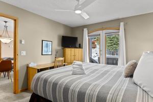 a bedroom with a bed and a desk and a window at Crystal Forest #51 condo in Sun Peaks