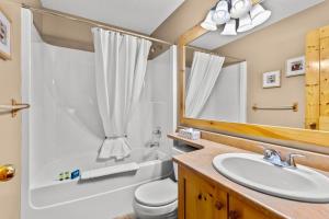 a bathroom with a sink and a toilet and a mirror at Crystal Forest #51 condo in Sun Peaks