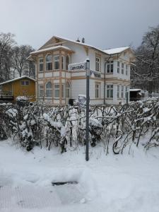 a house with a street sign in the snow at Lange am Meer in Heringsdorf +12 photos