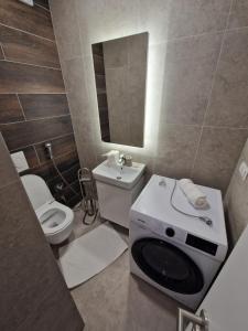 ein Badezimmer mit einem WC und einer Waschmaschine in der Unterkunft Sarajevo Waves Aparthotel in Sarajevo