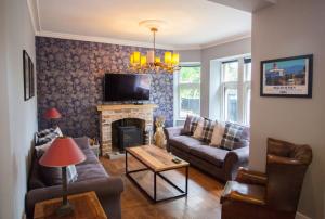 a living room with a couch and a fireplace at Stylish Loch Lomond lodge in stunning surroundings in Balloch