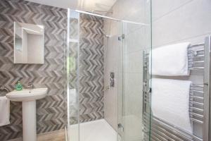 a bathroom with a glass shower and a sink at Stylish Loch Lomond lodge in stunning surroundings in Balloch