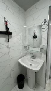 W białej łazience znajduje się umywalka i lustro. w obiekcie Islomobod w mieście (( Yangi-Abad ))