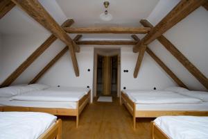 three beds in a room with wooden beams at Farm Soržev mlin in Nova Cerkev