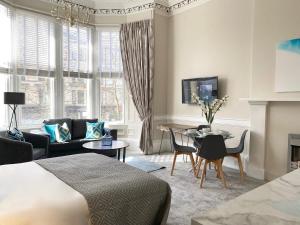 a living room with a bed and a dining room at The Buckingham Studio in Glasgow