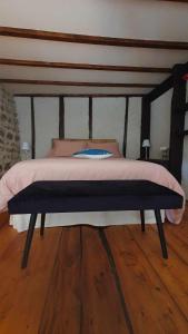 een bed in een slaapkamer met een houten vloer bij Les chambres de Solol in Félines