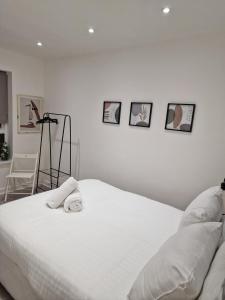 a bedroom with a white bed with four pictures on the wall at Bright Central Flat with Balcony and Free Parking in Glasgow