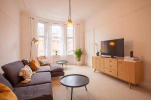a living room with a couch and a flat screen tv at Stunning 2 bed property in heart of West End in Glasgow
