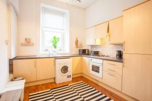 a kitchen with a washing machine and a window at Stunning 2 bed property in heart of West End in Glasgow