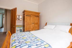 una camera con letto e armadio in legno di Modern, Light-filled and Sleek West End Apartment a Glasgow