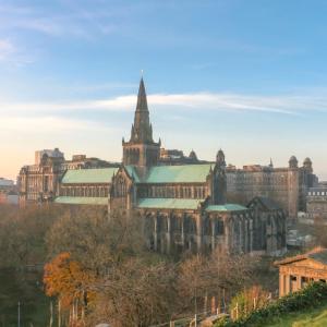 an old building with a tower and a church at Bright Central Flat with Balcony and Free Parking in Glasgow