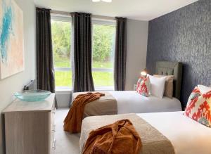 um quarto de hotel com duas camas e uma janela em Beautiful West End Flat with Private Parking em Glasgow