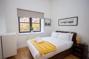 um quarto com uma cama com um bicho de peluche num cobertor em Glasgow Green Getaway with Free Parking em Glasgow