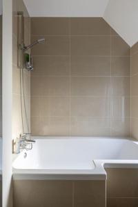 a bathroom with a white tub and a sink at Flat in Guildford in Stoughton