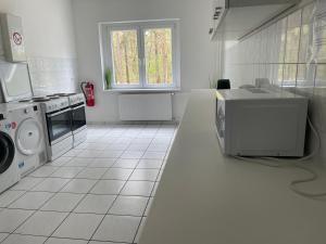 a white kitchen with a stove and a microwave at A2rooms in Lehnin