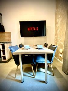a white table with blue chairs and a netflix sign at WATERFRONT - Urbane Eleganz am Bachufer in Villach