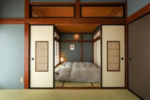 大野市にある貸切民泊宿 だんねだんね Private guest house Danne-Danneのドア付きの部屋にベッド1台が備わるベッドルーム1室があります。