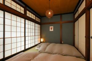 Cama en habitación con ventanas grandes en 貸切民泊宿 だんねだんね Private guest house Danne-Danne en Ōno