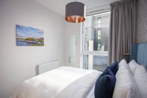 a bedroom with a white bed and a window at 1 Bedroom Apartment in Very Central Location in Glasgow