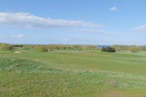 uitzicht op een golfbaan met een groen veld bij Ostseetraum - Lütt Heimaad Whg 32 - Hohen Wieschendorf in Hohen Wieschendorf