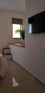 a bedroom with a flat screen tv on a wall at Bright & modern studio,Sliema in Sliema