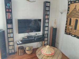 a living room with a television and a coffee table at Romans-sur-Isère, maison de rue en centre ancien in Romans-sur-Isère