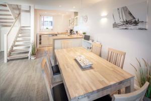 Rettin的住宿－Ocean 1，厨房以及带木桌和椅子的用餐室。