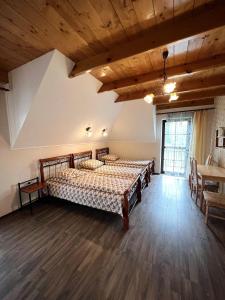 a bedroom with two beds and a wooden floor at Willa Na Krańcu Kazimierza in Uściąż
