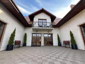 a patio with chairs and a balcony on a building at Willa Na Krańcu Kazimierza in Uściąż