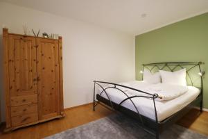 布萊特瑙的住宿－Ferienwohnung "Dorfliebe" mit privater Sauna und 4 Schlafzimmern in Breitnau，一间卧室配有一张床和一个木制橱柜