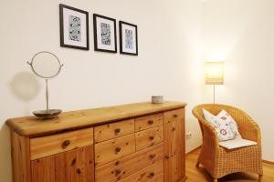 a wooden dresser with a mirror and a chair at Ferienwohnung "Dorfliebe" mit privater Sauna und 4 Schlafzimmern in Breitnau in Breitnau