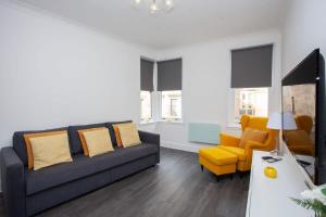 a living room with a couch and a yellow chair at Newly Renovated City Apartment in Glasgow