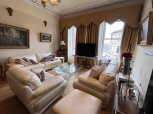 a living room with two couches and a television at Stunning West End 3 Bed in Glasgow